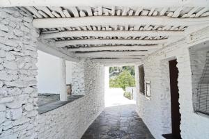 Casa Rural Vata 1 y 2 Pampaneira Alpujarra في بامبانيرا: مدخل مبنى حجري بسقف خشبي