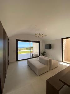 sala de estar con sofá blanco y ventana grande en Domo La Vela, en Cala Liberotto