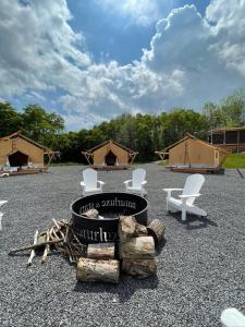 eine Gruppe von Stühlen und einem Grill und einige Zelte in der Unterkunft Naturluxe & Stars in Watkins Glen