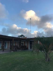 ein Gebäude mit einer Palme davor in der Unterkunft Hostal Lo de Mili in Chuy