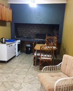 a living room with a fireplace and a table and chairs at Hostal Lo de Mili in Chuy