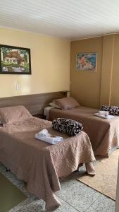 een hotelkamer met 2 bedden en handdoeken erop bij Hotel Dom Daniel in Palmares