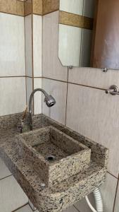 PalmaresHotel Dom Daniel的浴室内的石水槽和镜子