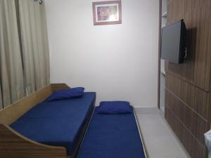 Habitación pequeña con 2 camas y TV. en Apartamento Diroma Lacqua 3 en Caldas Novas