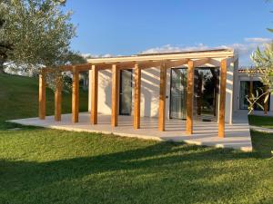 a house with wooden columns and a deck at Agriturismo Baglio San Nicola in Naro