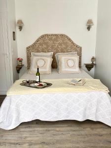 ein Bett mit einer Flasche Wein und ein Tablett mit einer Flasche Champagner in der Unterkunft LE VIEUX MOULIN in Bouhet