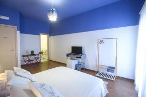 ein Schlafzimmer mit einem weißen Bett und einer blauen Wand in der Unterkunft San Domenico in Bari