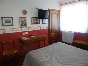 a bedroom with a bed and a tv on the wall at Hotel Leku Eder in San Sebastián