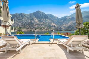 a villa with a swimming pool and mountains at Dekaderon Lux Apartments in Kotor