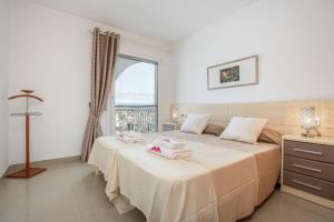 1 dormitorio con 2 camas y ventana en Apart-rent Penthouse Port Grec 0160, en Empuriabrava