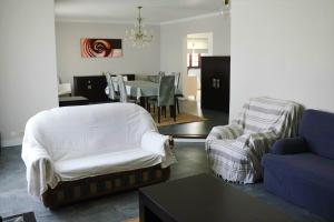 ein Wohnzimmer mit Sofa, Stühlen und einem Tisch in der Unterkunft Casa Branca in Ericeira