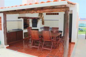 ein Esszimmer mit Tisch und Stühlen und eine Küche in der Unterkunft Casa Branca in Ericeira