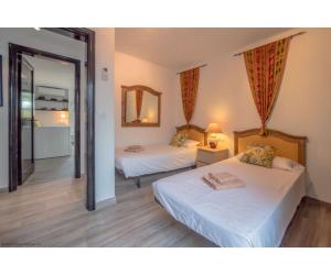 a hotel room with two beds and a mirror at Puerto Chico I and J in Playa Blanca +11 photos