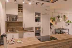 a kitchen with white cabinets and a counter top at Superbe Appart Plein Centre avec Parking & Jardin in Metz