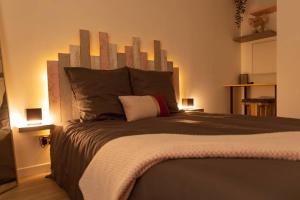 a bedroom with a large bed with a wooden headboard at Superbe Appart Plein Centre avec Parking & Jardin in Metz