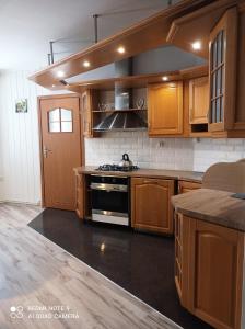 eine Küche mit Holzschränken und einem Herd mit Backofen in der Unterkunft Apartament Piłsudskiego in Świnoujście