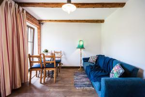 a living room with a blue couch and a table at Dom Pod Orzechem in Łapczyca