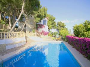 a swimming pool in front of a house with purple flowers at Holiday Home Marina 8 in Jávea