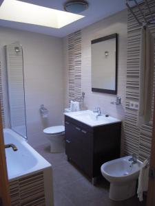 a bathroom with a sink and a toilet and a mirror at Casa Rural Carmina in Berlanga de Duero