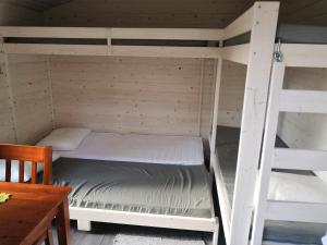 a bedroom with two bunk beds and a table at Mäentaustan aitat in Janakkala