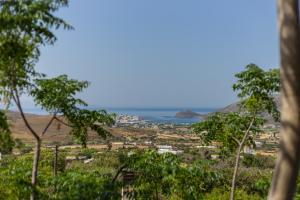 a view of a city from a hill with trees at Andros Melissari in Koumárion