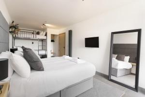 a white bedroom with a large bed and a mirror at The Old House 1147 in Bridgend
