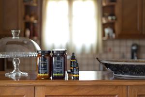 a counter with two bottles of honey and a bowl at Andros Melissari in Koumárion +37 photos