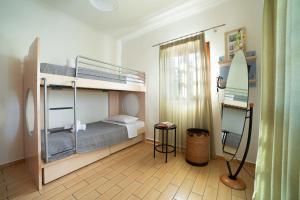 a bedroom with two bunk beds and a surfboard at Andros Melissari in Koumárion