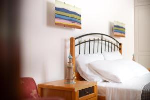 a bedroom with a bed and a table with a lamp at Andros Melissari in Koumárion