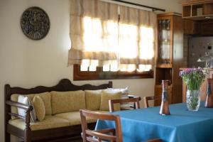 a living room with a couch and a table with a blue table cloth at Andros Melissari in Koumárion