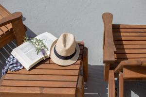 a hat sitting on a bench with a book at Andros Melissari in Koumárion