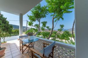 a patio with a table and chairs on a balcony at Andros Melissari in Koumárion