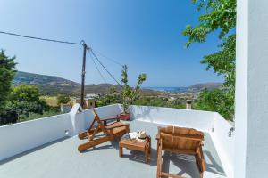 a view from the balcony of a house with chairs and tables at Andros Melissari in Koumárion
