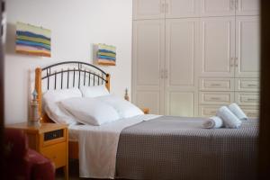 a bedroom with a bed with white pillows at Andros Melissari in Koumárion