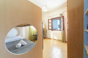 a room with a bed with a mirror on the wall at Andros Melissari in Koumárion