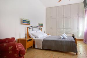 a bedroom with a bed and a chair at Andros Melissari in Koumárion