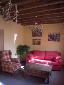 a living room with a red couch and a coffee table at Casa Rural Carmina in Berlanga de Duero
