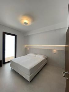 Un dormitorio blanco con una cama grande. en Domo La Vela, en Cala Liberotto
