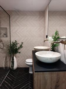 ein Badezimmer mit einem Waschbecken, einem WC und einem Spiegel in der Unterkunft Sol y Malaga - Designer Duplex con Terraza y Parking in Málaga