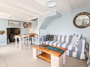 a living room with a couch and a table at 2 Cliff Cottages in Truro