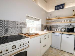 a kitchen with white appliances and a window at 2 Cliff Cottages in Truro