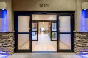 Holiday Inn Express & Suites Wheat Ridge-Denver West, an IHG Hotel في ويت ريدج: مدخل لمبنى بأبواب زجاجية