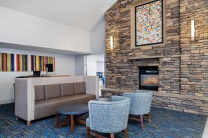 hol z kanapą, krzesłami i kominkiem w obiekcie Holiday Inn Express & Suites Wheat Ridge-Denver West, an IHG Hotel w mieście Wheat Ridge