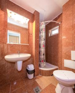 uma casa de banho com um lavatório, um WC e uma banheira em Hotel Raluca em Venus