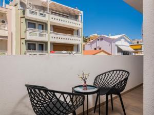 een tafel en stoelen op een balkon met een gebouw bij Blush & Crema Apartments in Zakynthos