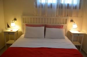 a bed with two white pillows and a red blanket at Liogerma apartments in Ierissos