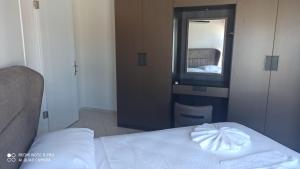 - une chambre avec un lit blanc et un miroir dans l'établissement Riverside villas, à Ortaca