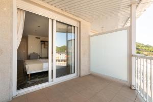 una gran puerta corredera de cristal que da a un balcón con cama en Hotel Condado Ourense, en Ourense