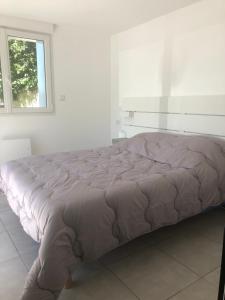 een groot bed in een witte kamer met een raam bij Dar Lila Cote d'Opale in Saint-Martin-Boulogne
