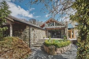 a stone house with a porch and stairs to it at Shepherd's View in Kendal